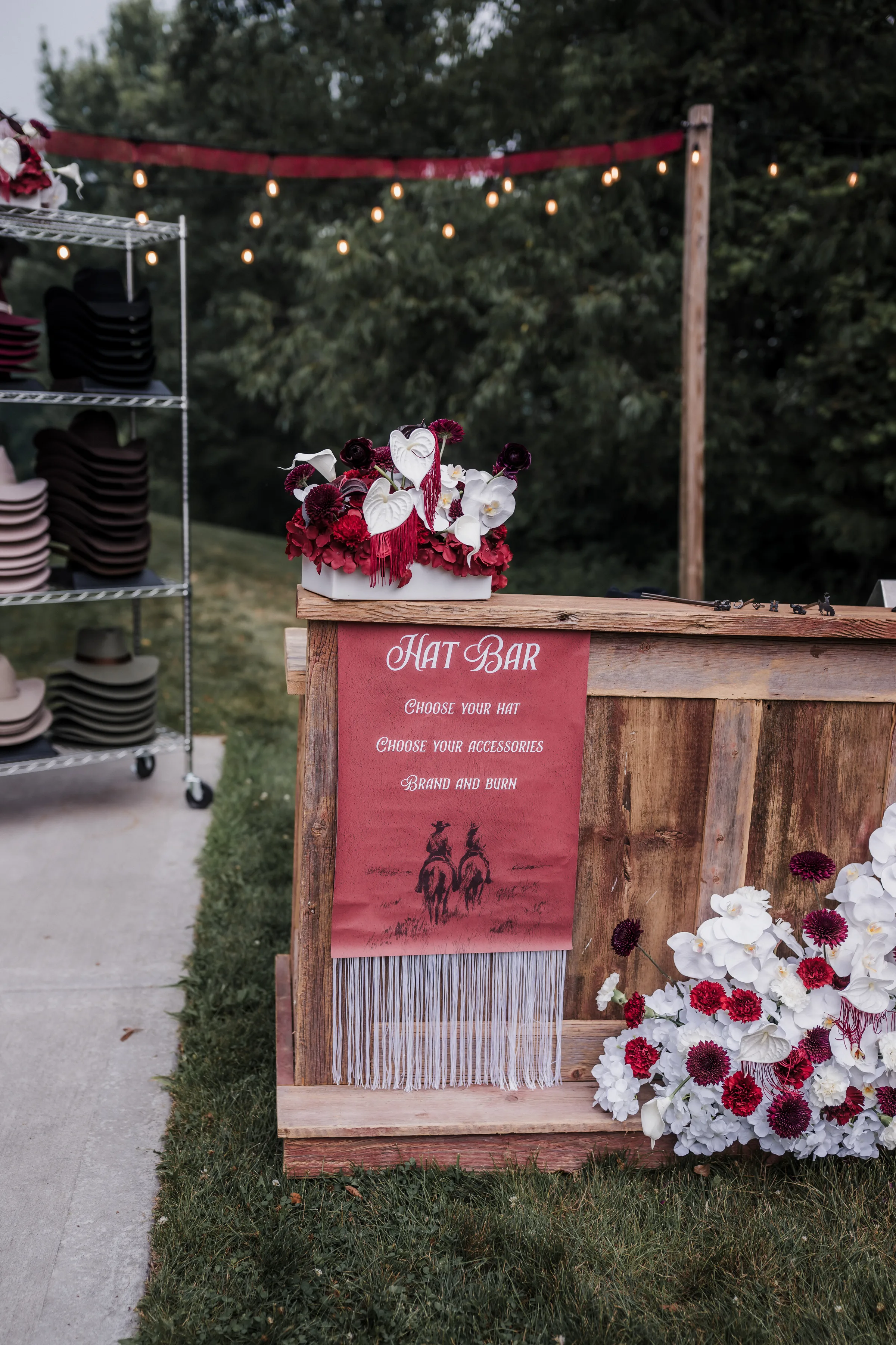 custom hat bar signage from LK Bridal Studio with tassels and an illustration of two cowboys riding off into the distance