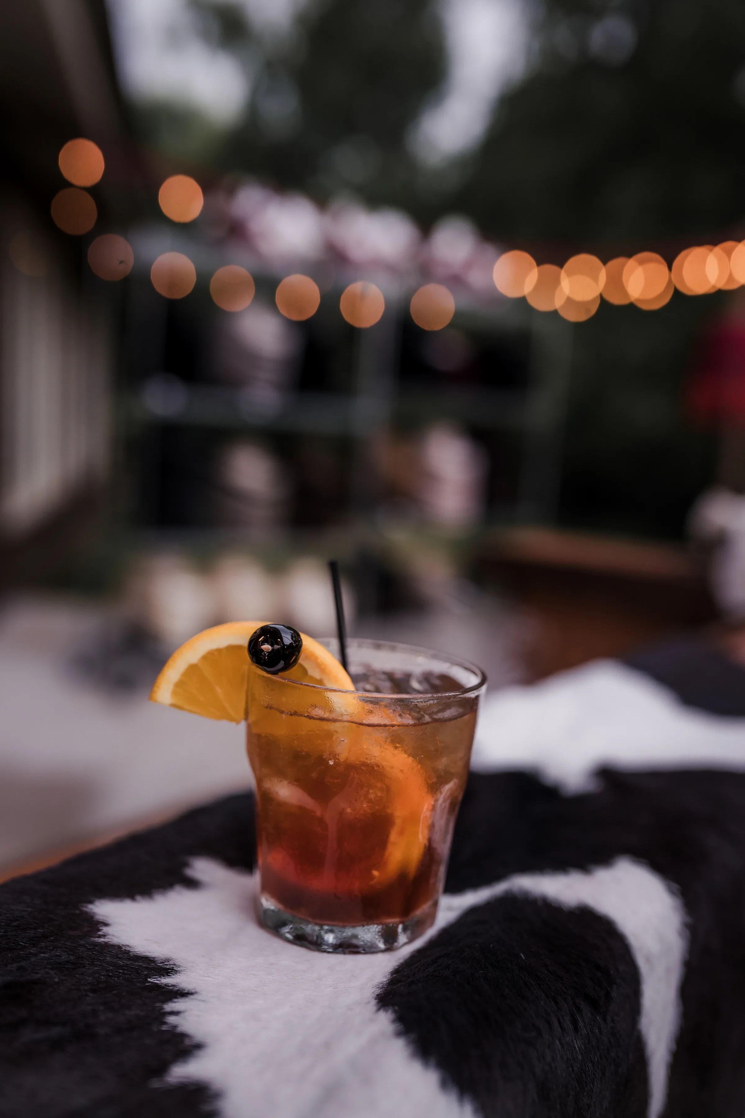 a detail photo of a wedding drink placed on black-and-white cowhide décor