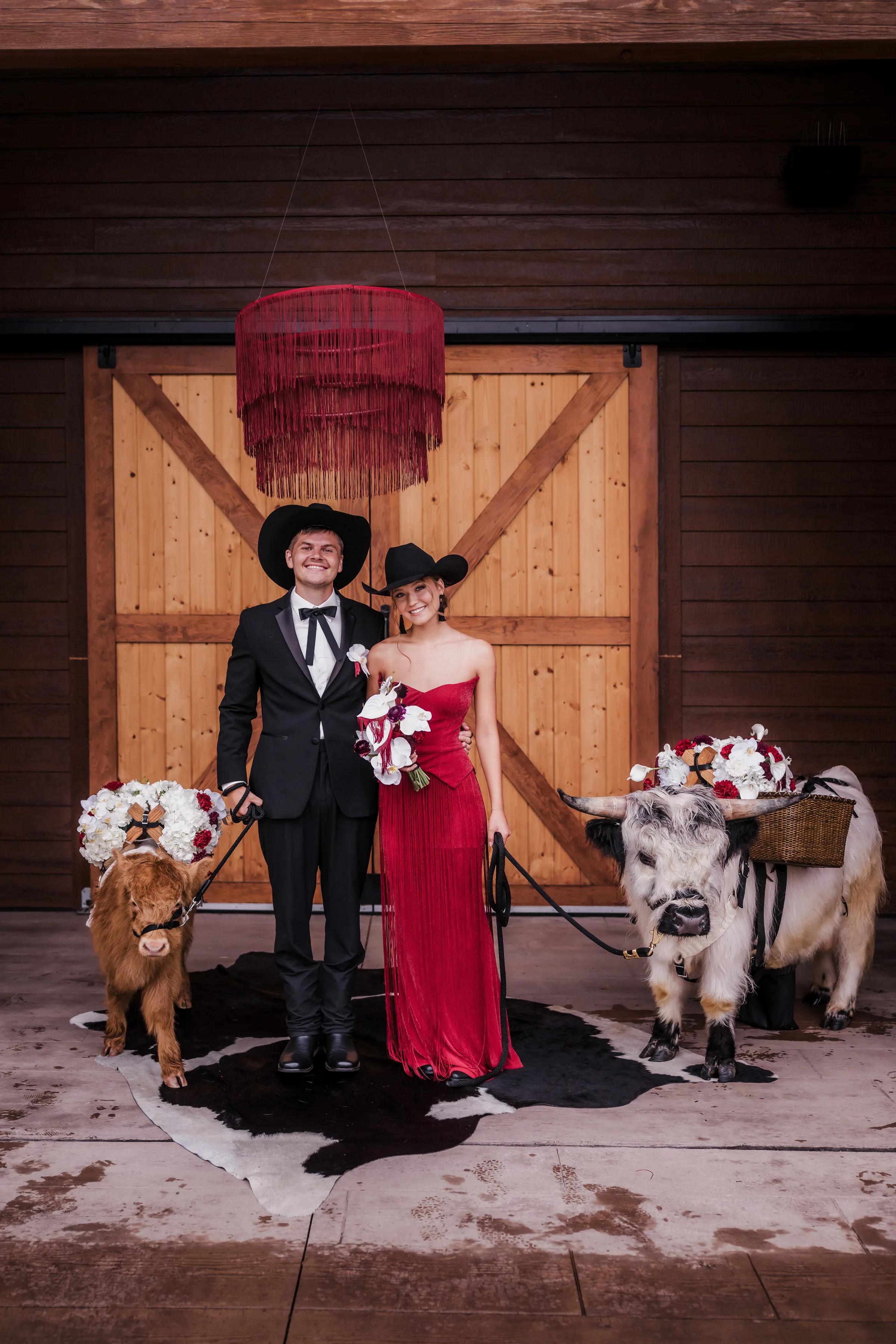wedding guests pose at Barnwood Events beside two beverage steers from Tiny Acre Farms