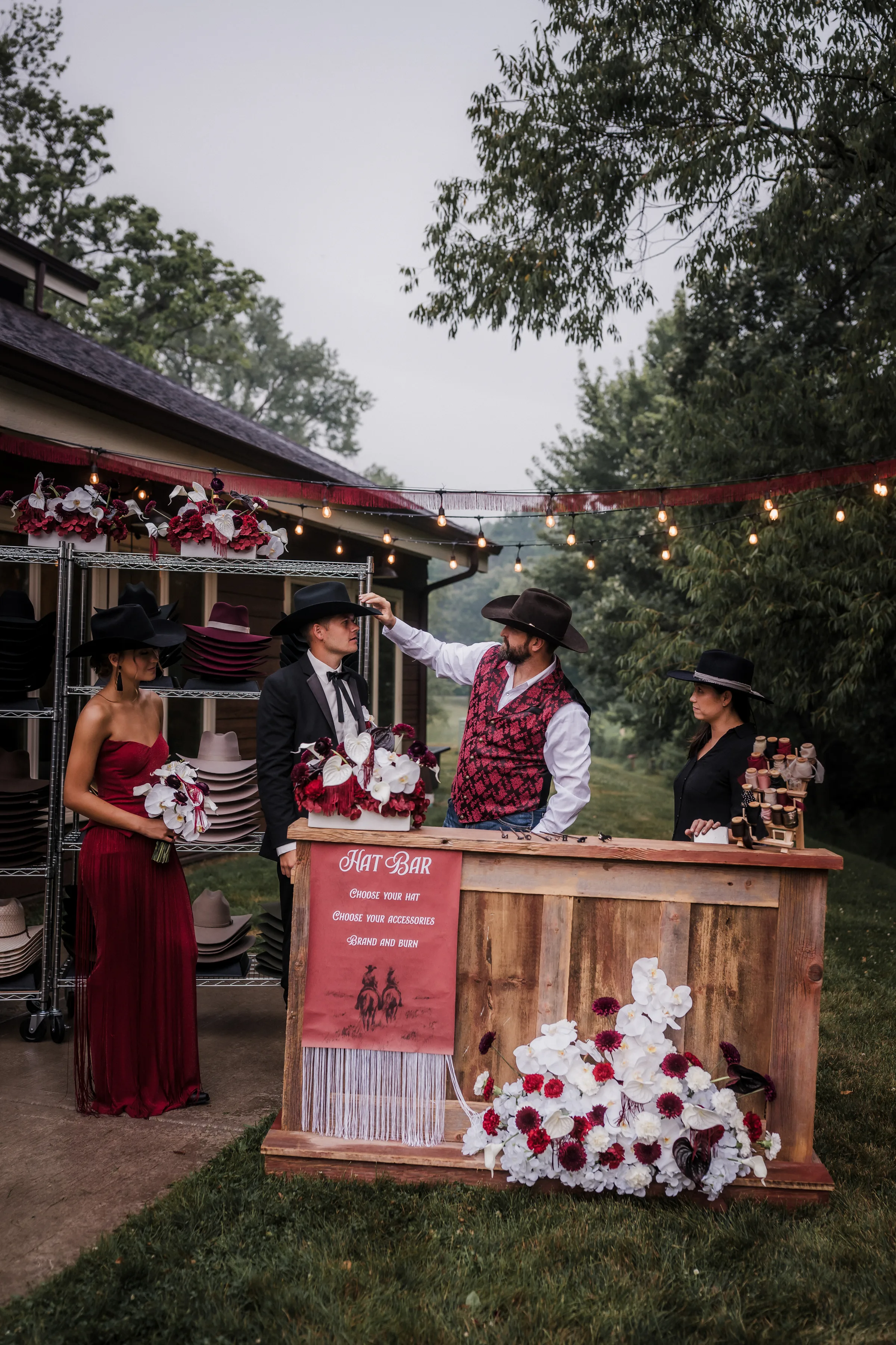 the groom and wedding guests interact with a custom cowboy hat bar from Hangman Hats