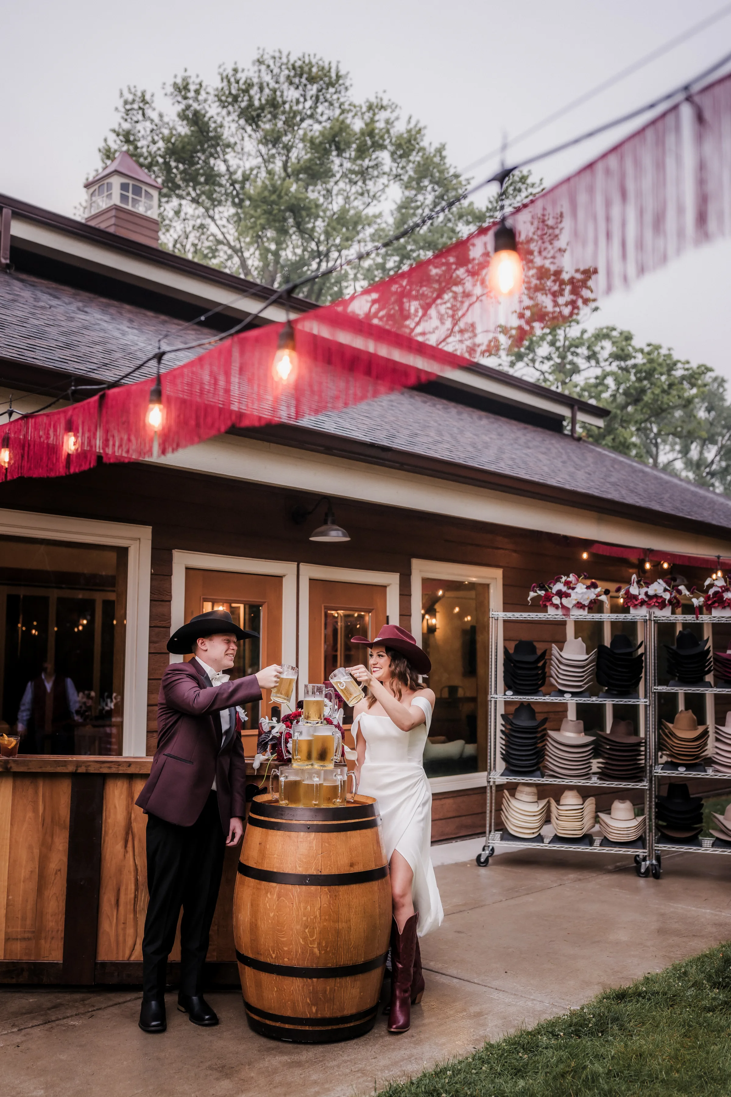 bride and groom models toast beer steins next to a beer tower and bar at a modern cowboy wedding at Barnwood Events