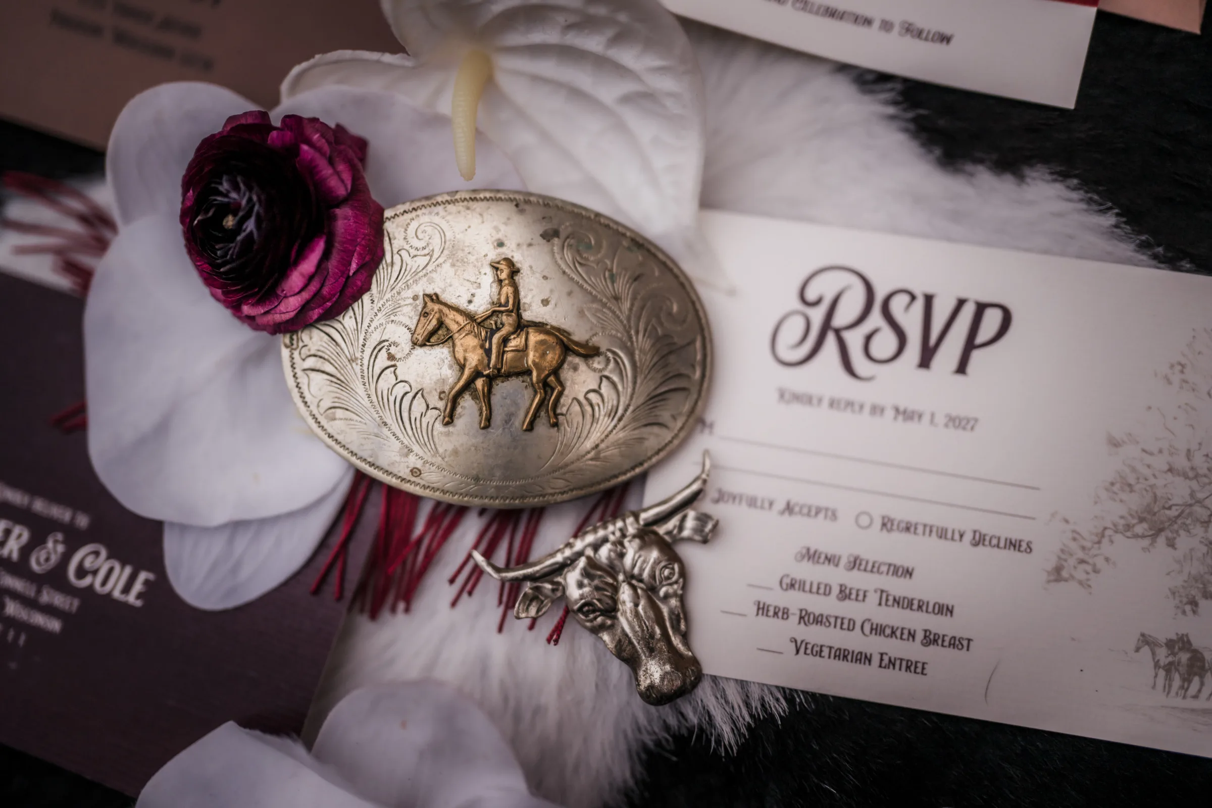 a silver and gold oval cowboy belt buckle depicting a man riding a horse