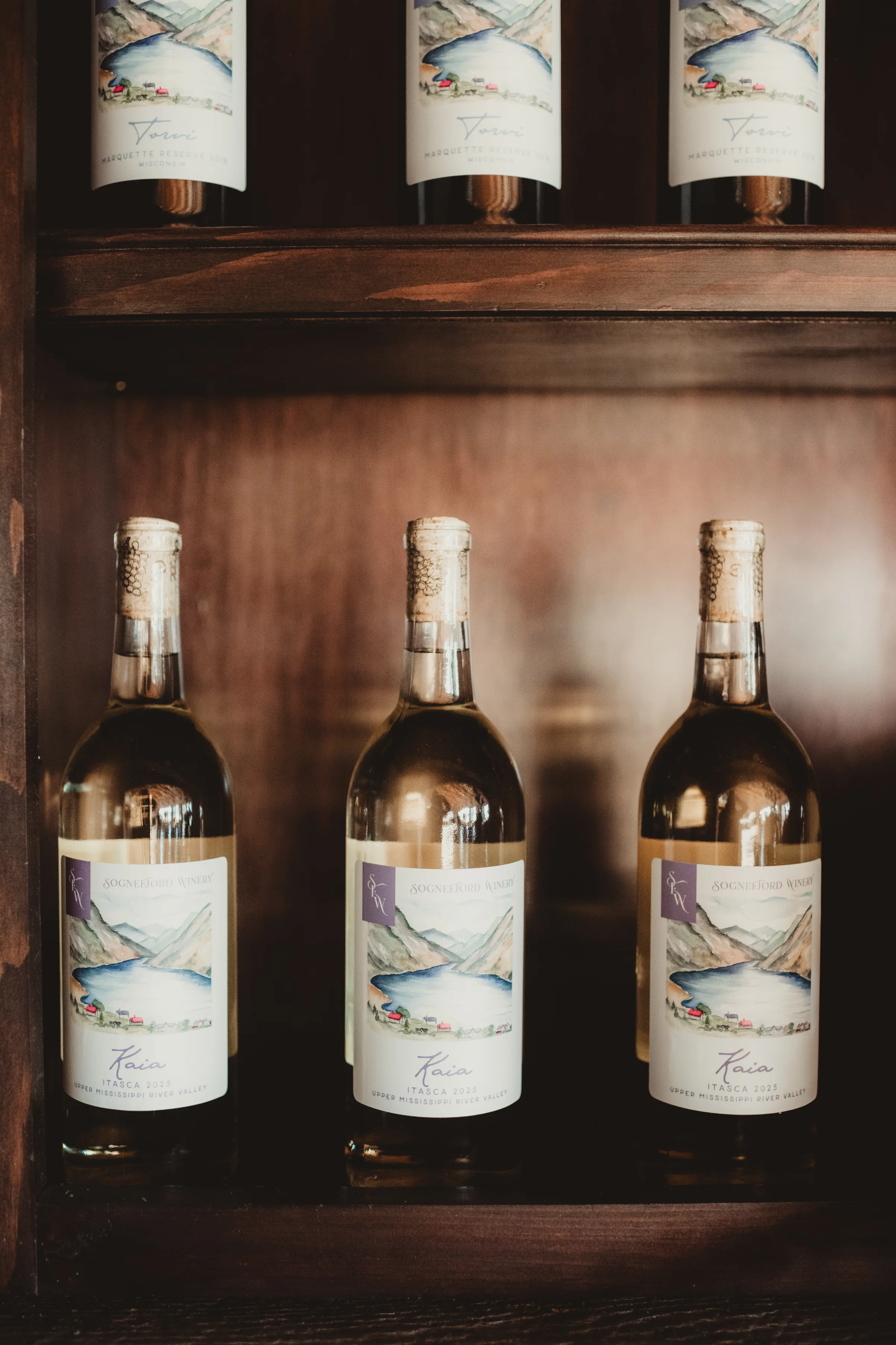 wine bottles sit on a shelf