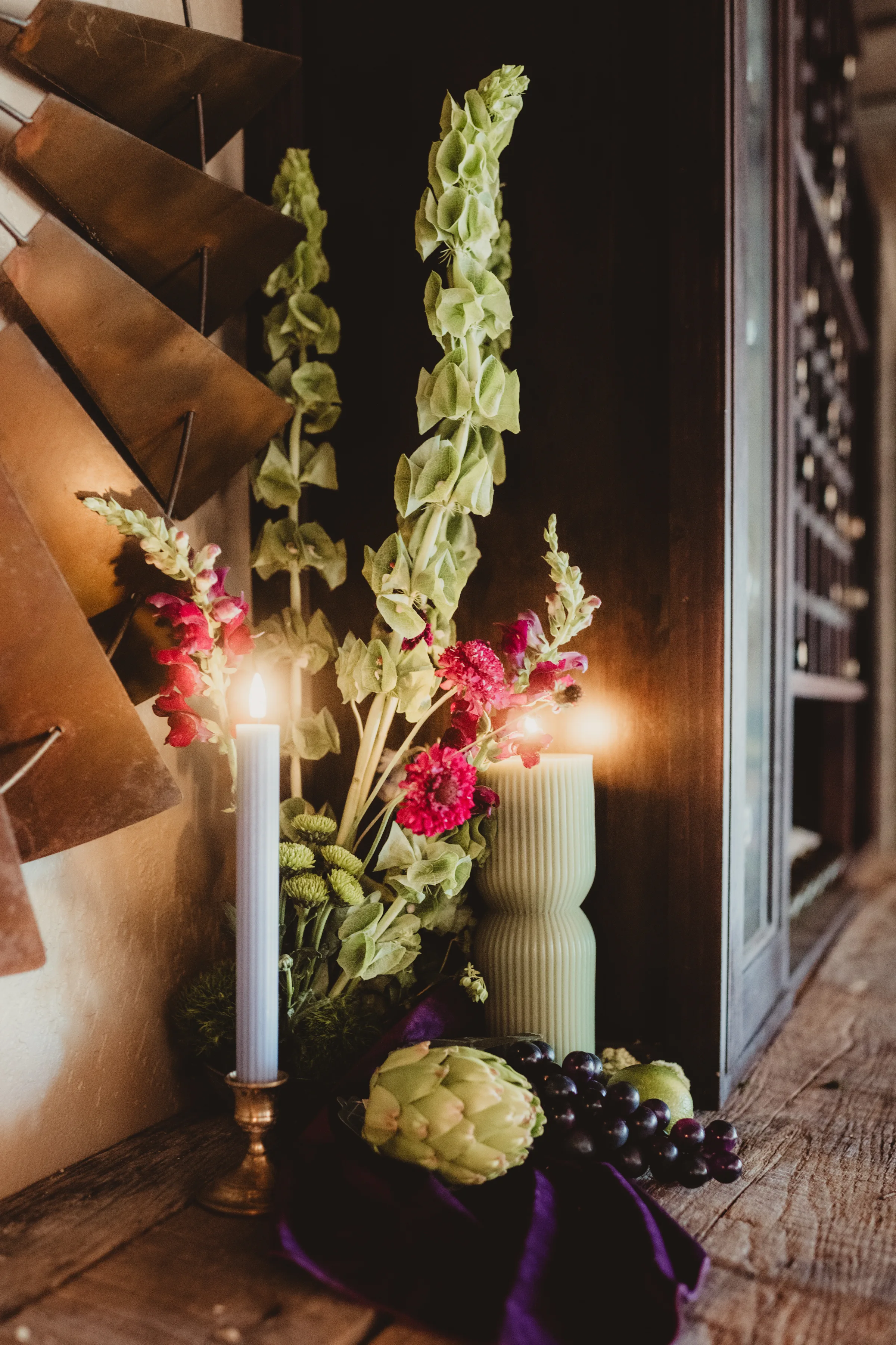 glowing candles sit beside florals and fruit as décor