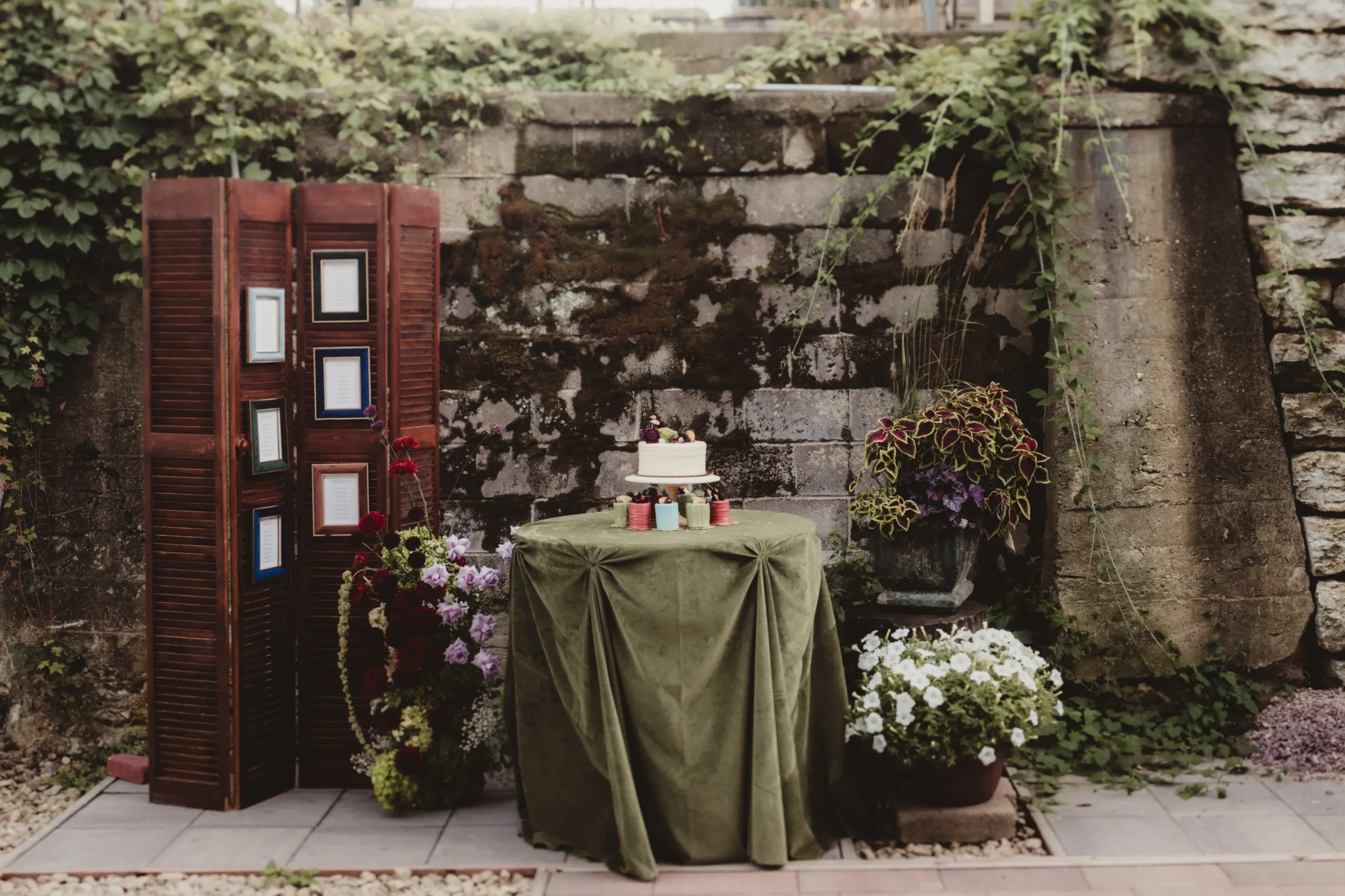 cocktail hour or outdoor reception spiced garden party inspiration showing a dessert table and framed seating chart wall