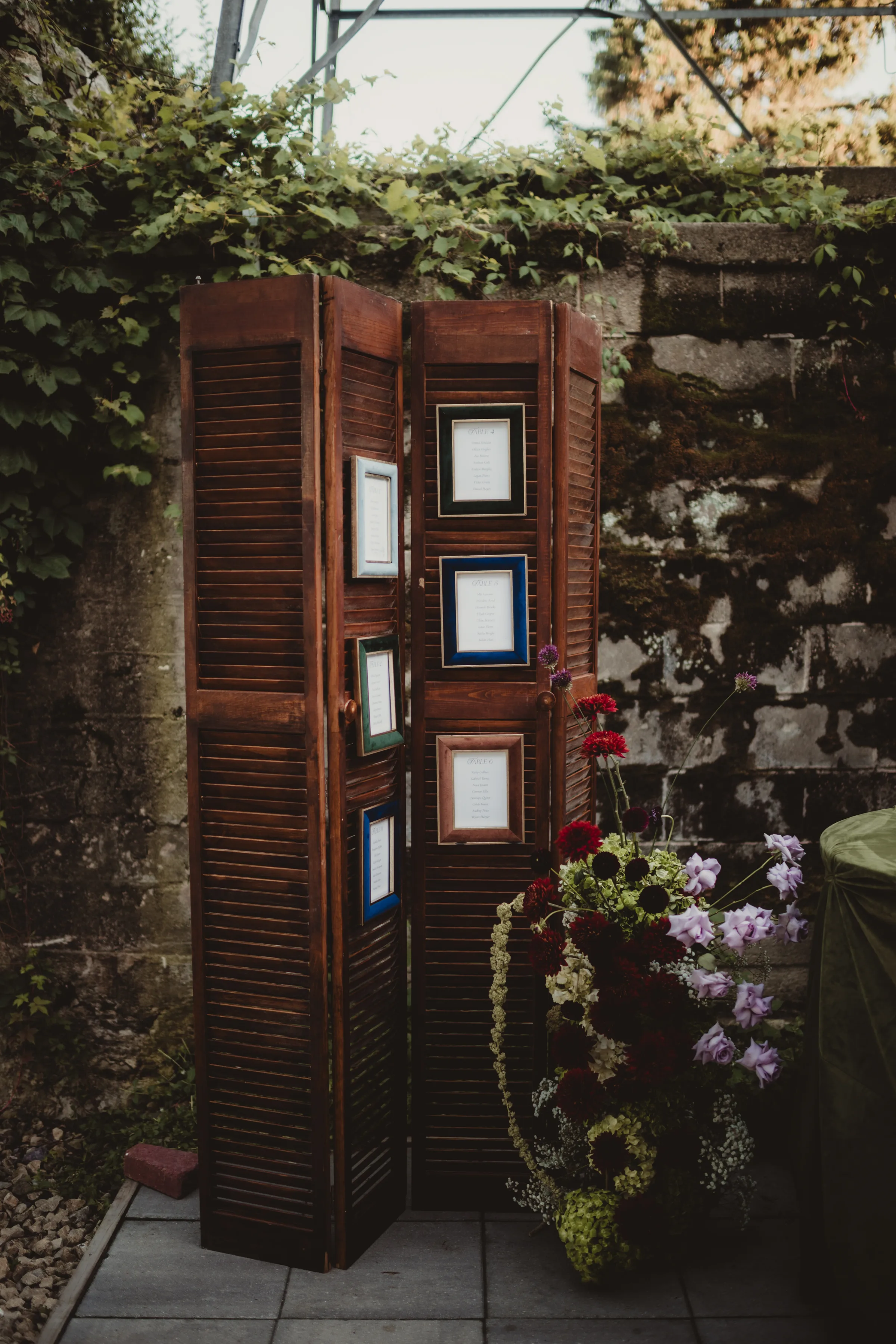 seating chart display inspiration, with vintage frames installed on a wooden room divider