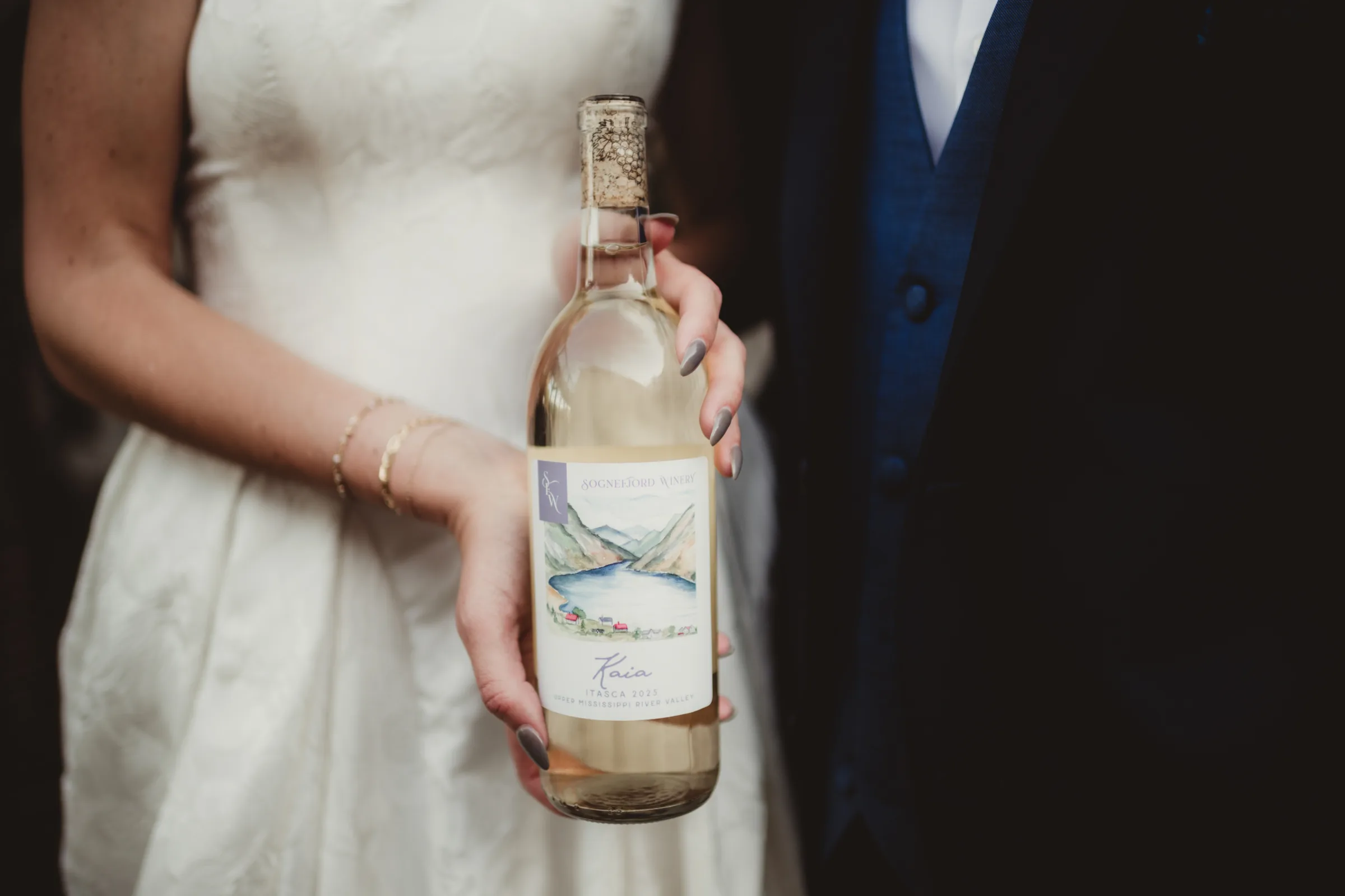 the bride holds out a wine bottle