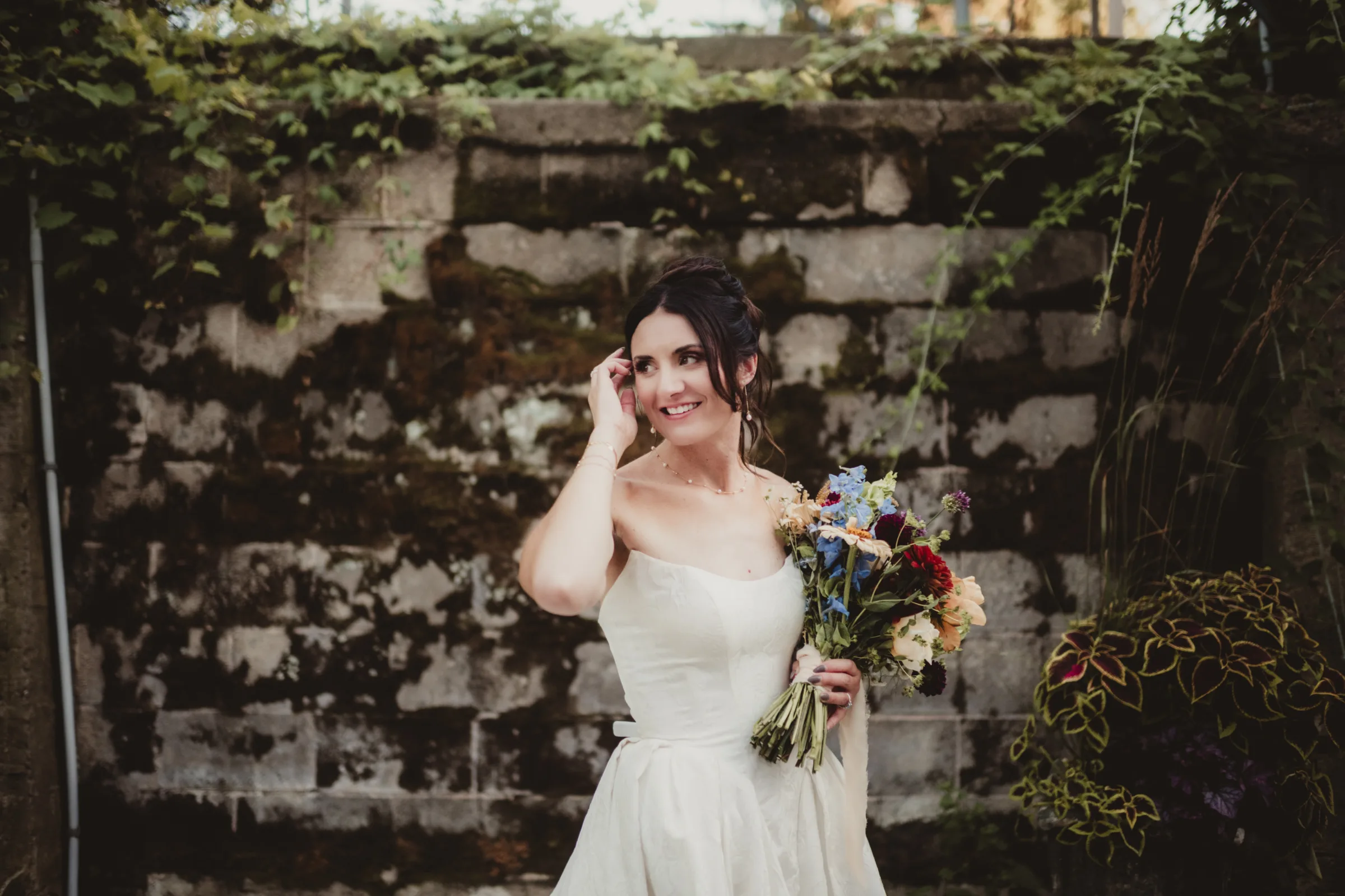 the bride casually smiles, holding a bouquet