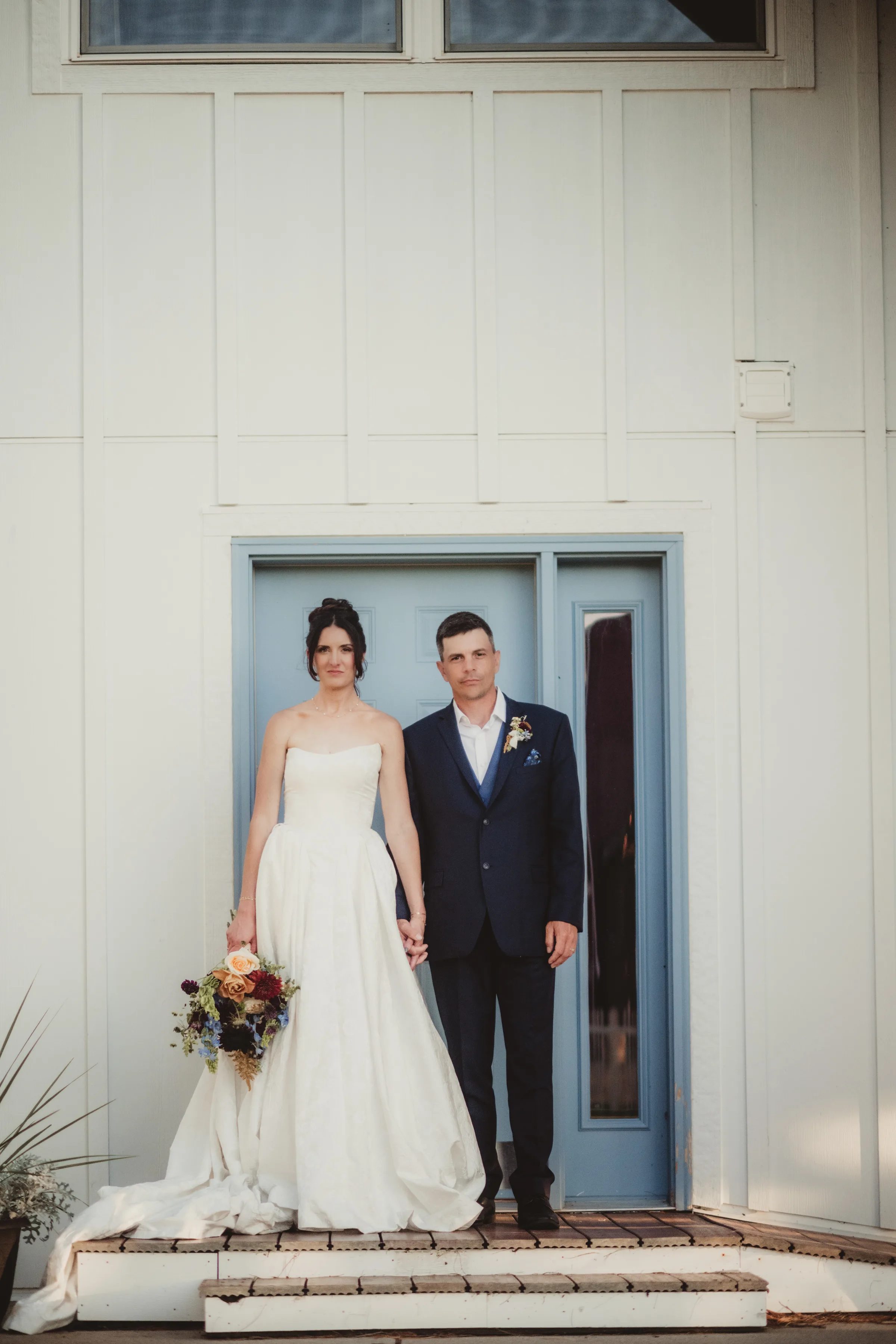 a serious photo of the bride and groom models holding hands