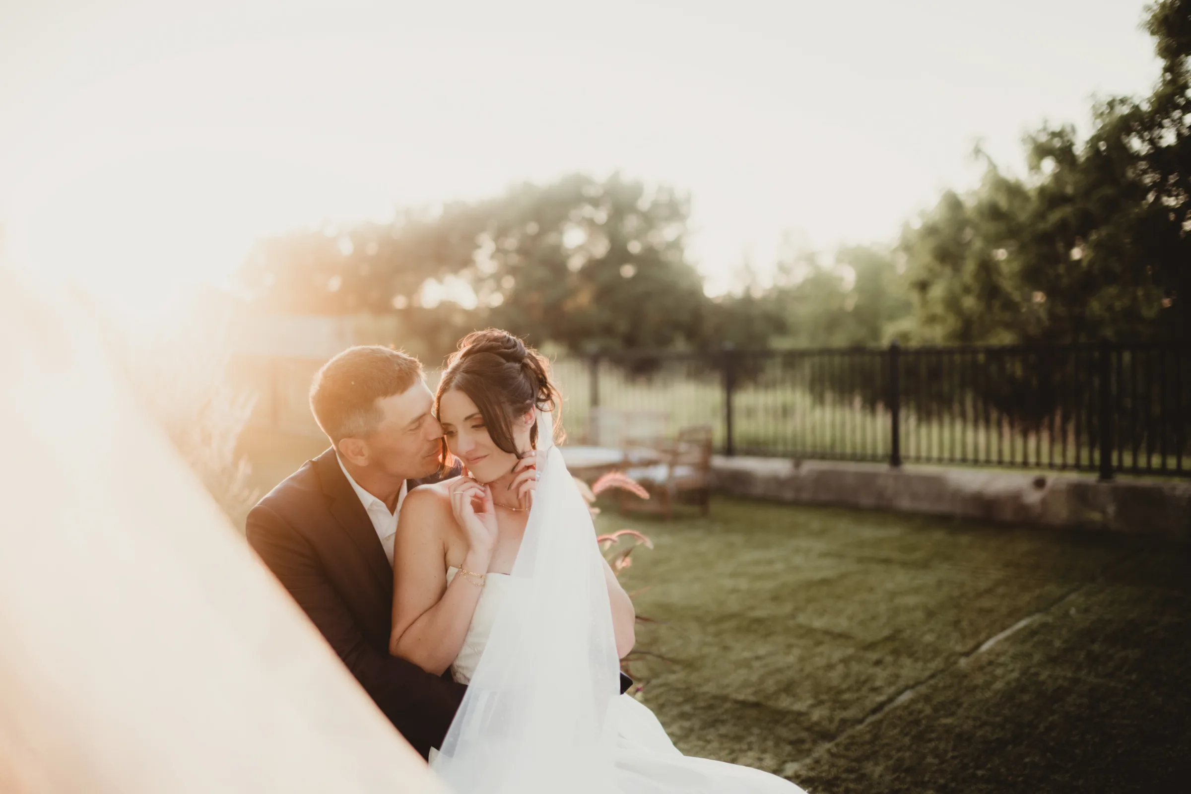 golden hour on the farm as the couple cuddles in close for sunset photos