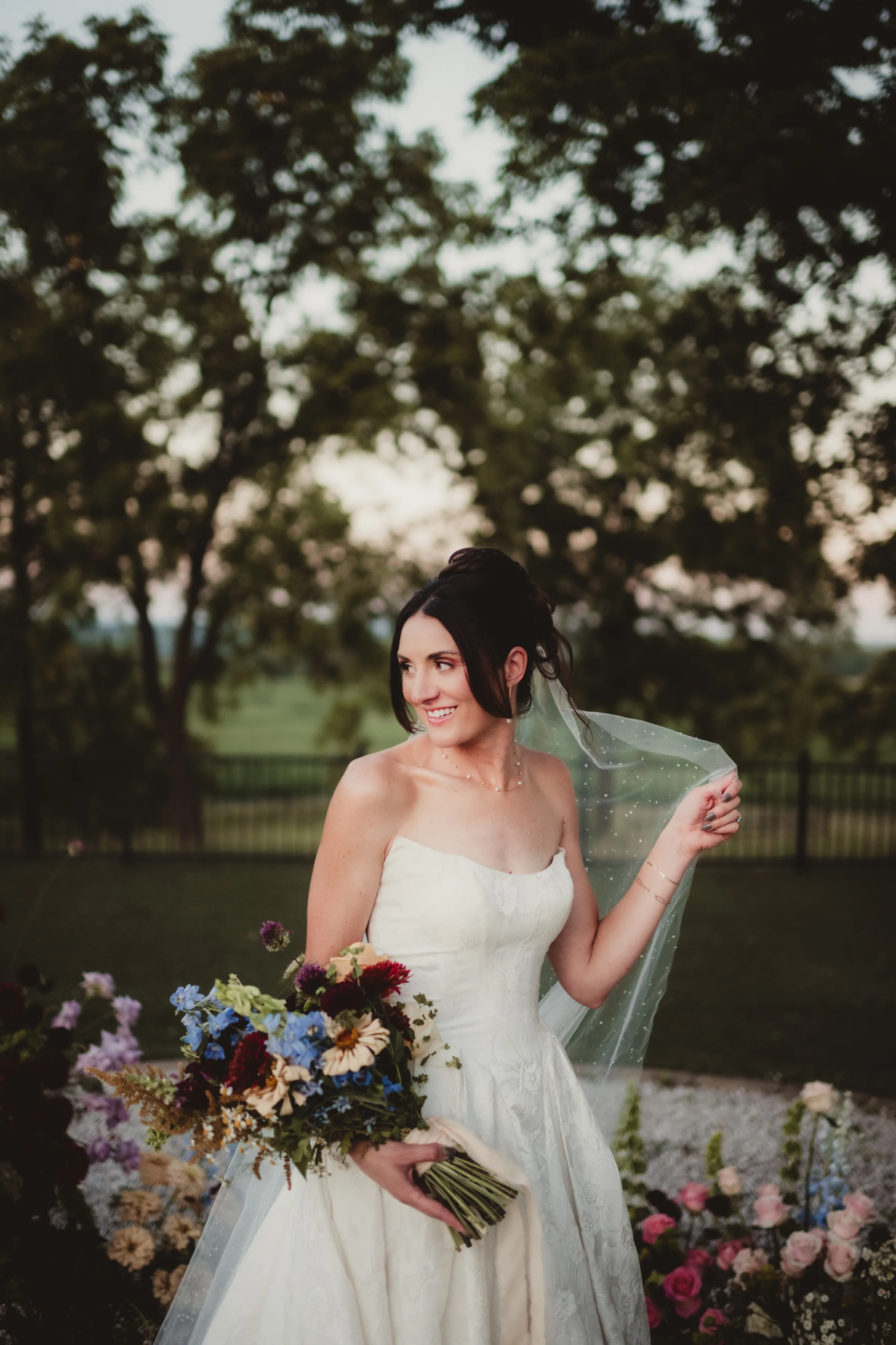 the bride model holds a colorful bouquet from Signature Events, featuring wildflower styling