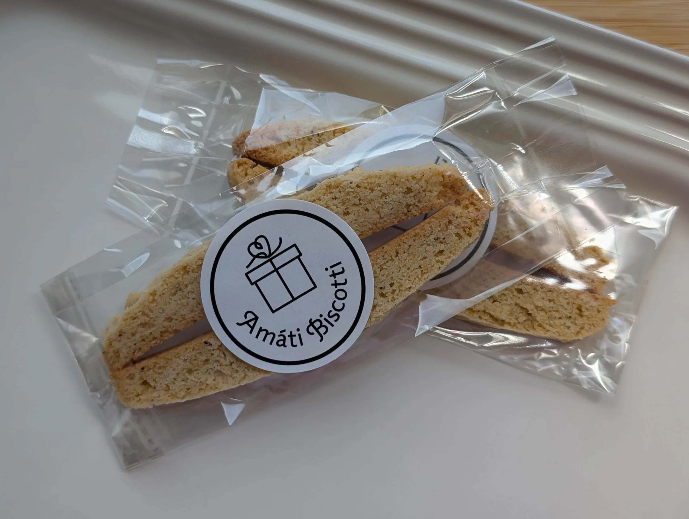 Amati Biscotti wedding favor — almond biscotti wrapped in a clear bag with Amati Biscotti gift box sticker