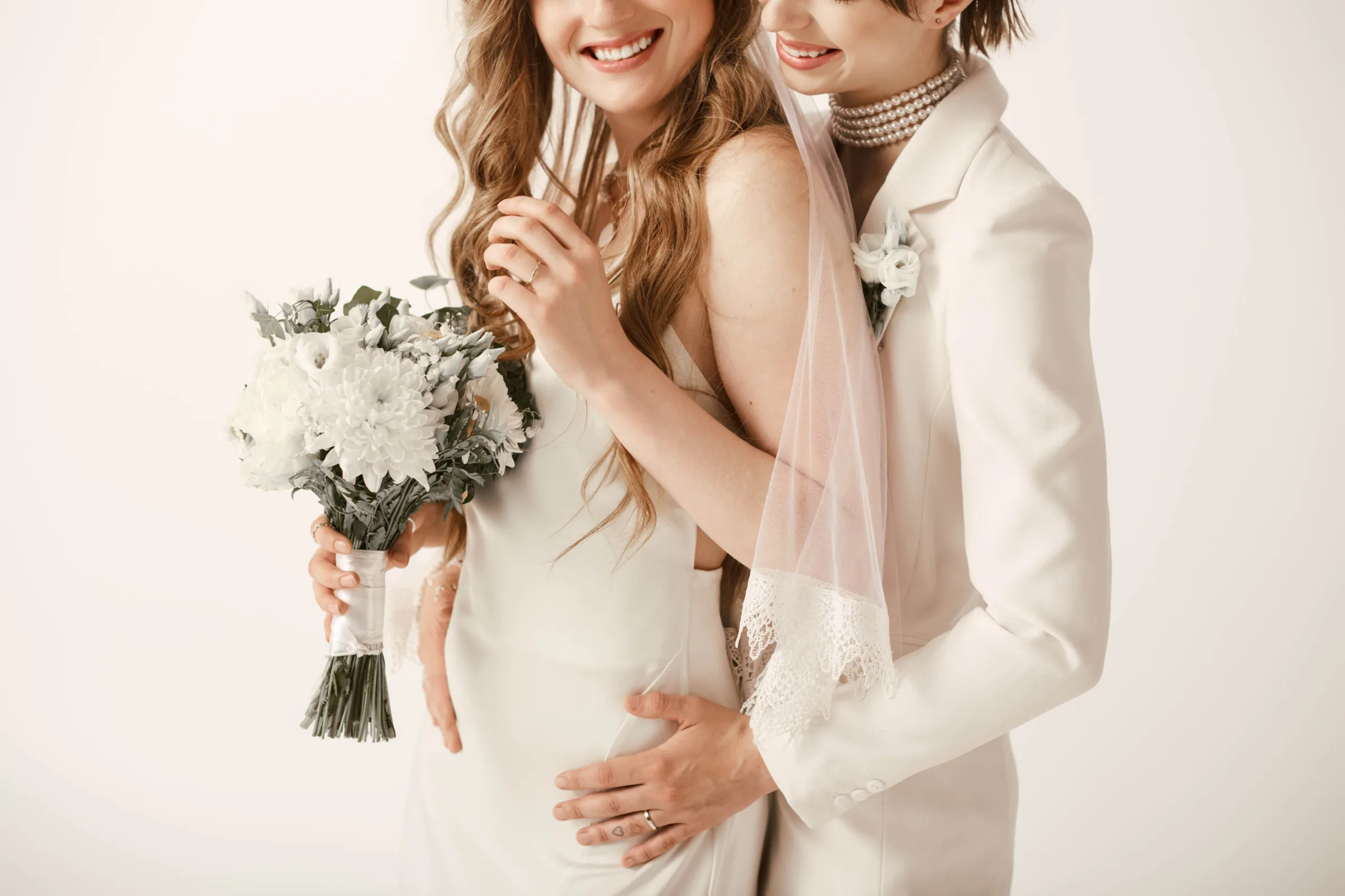A young lesbian couple, both dressed in white, share a tender mo