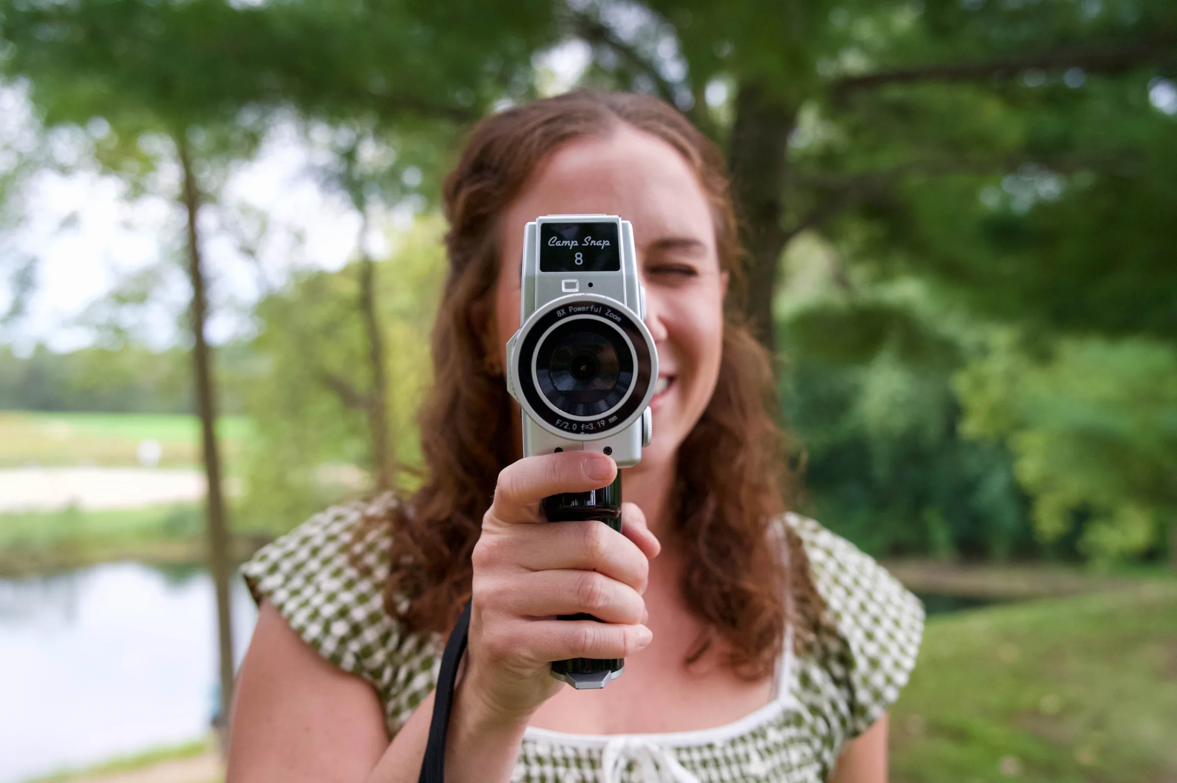 Andrea, the owner of Wi Do with Andrea, taking picture and video wedding content outside in a green dress in Madison, Wisconsin