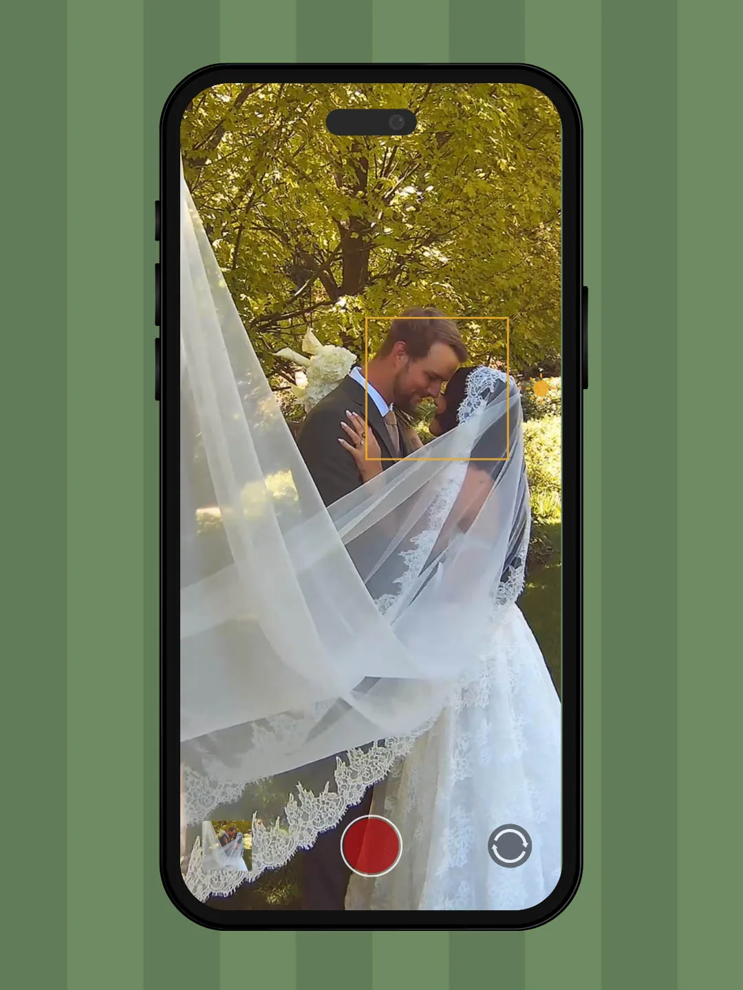 iPhone photo screen focused on a bride in a lace white dress with a cathedral veil and a groom in a tuxedo
