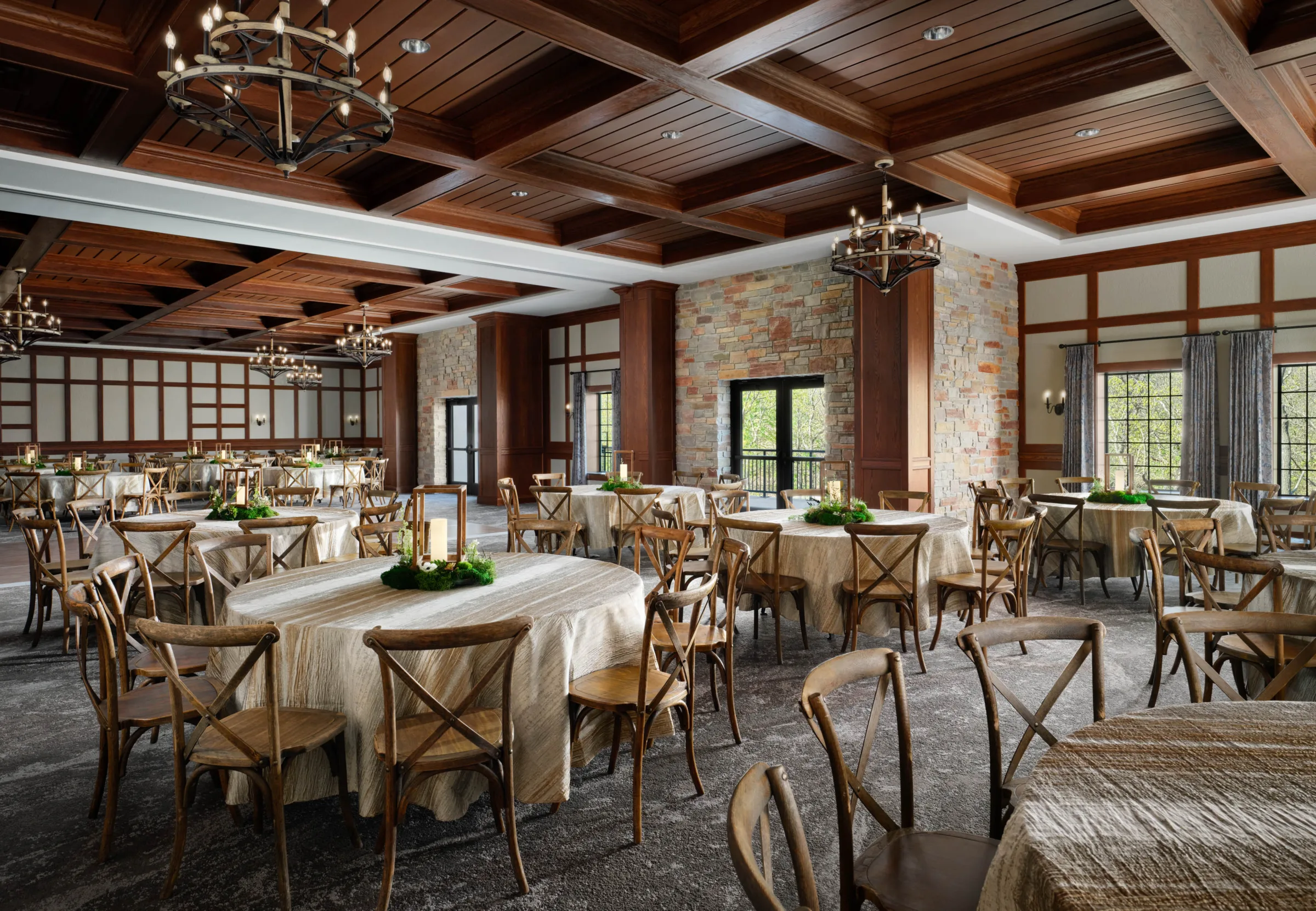 Grand Chaucer-Troyes Ballroom at Dellshire Resort, a luxury Wisconsin Dells wedding reception venue, featuring cross-back chairs, round tables, and rustic wood-paneled ceilings.