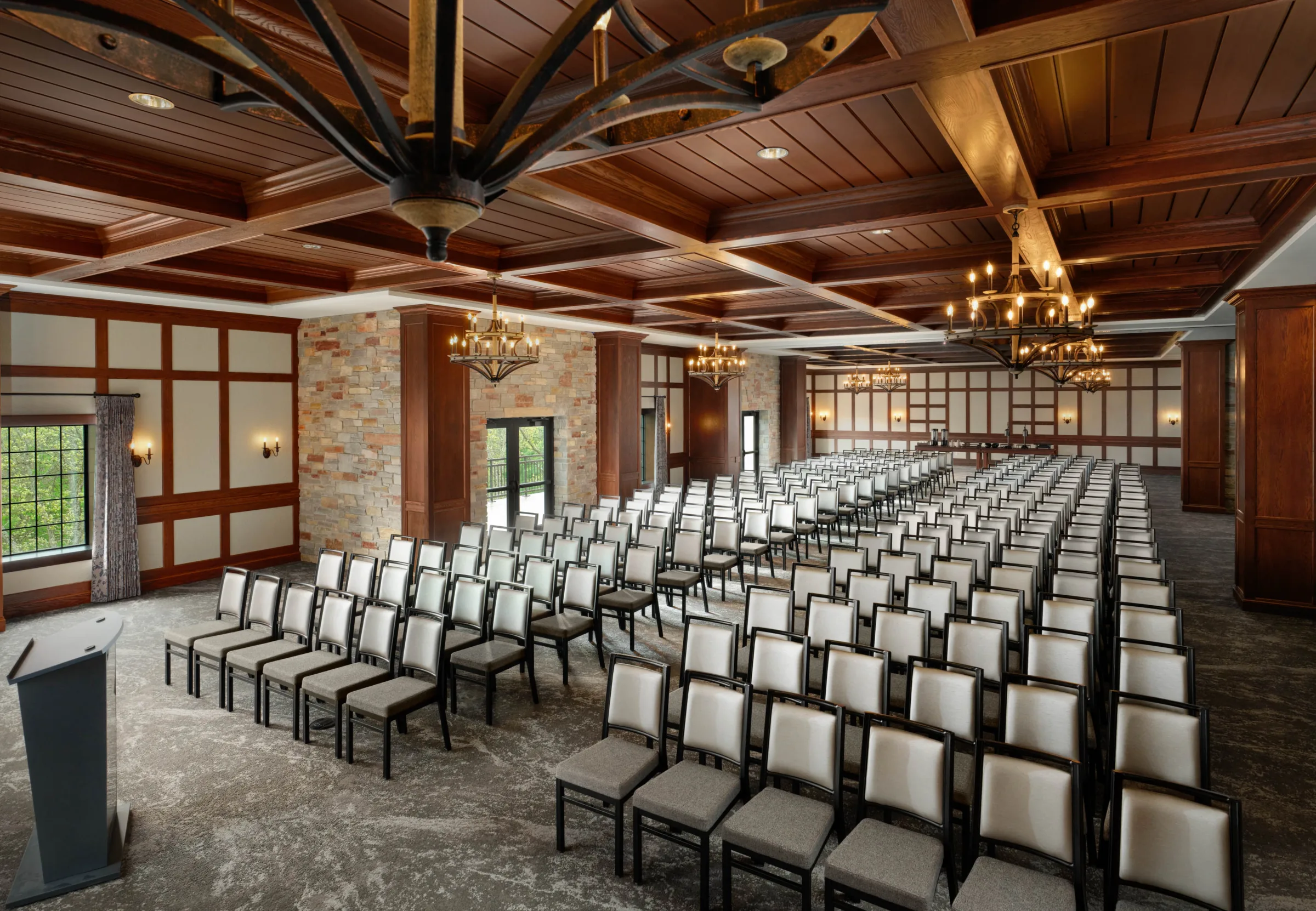 Indoor wedding ceremony setup at Dellshire Resort, a premier Wisconsin Dells event venue, showing theater-style seating with padded chairs and a wood coffered ceiling.